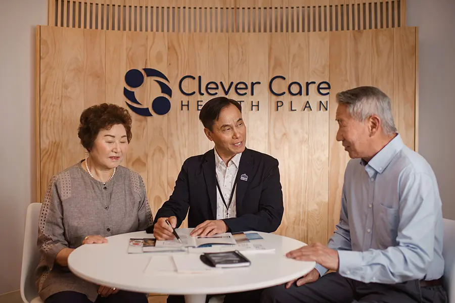 Clever Care team members greeting members at a community event table